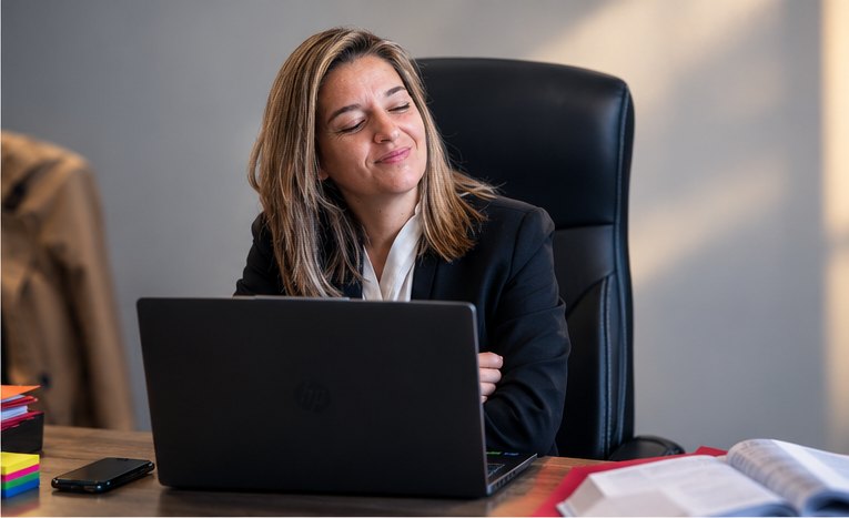 Abogada del despacho atendiendo a un cliente con una sonrisa